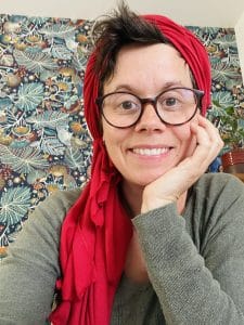Femme souriante avec foulard rouge et lunettes