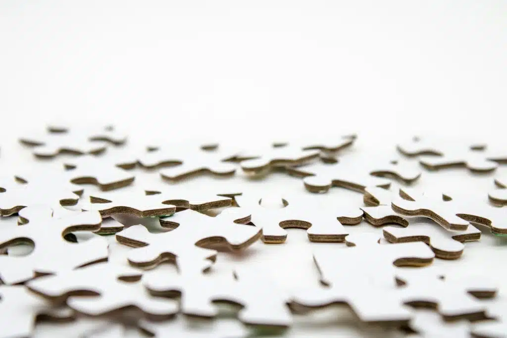 Pièces de puzzle blanches éparpillées sur fond blanc