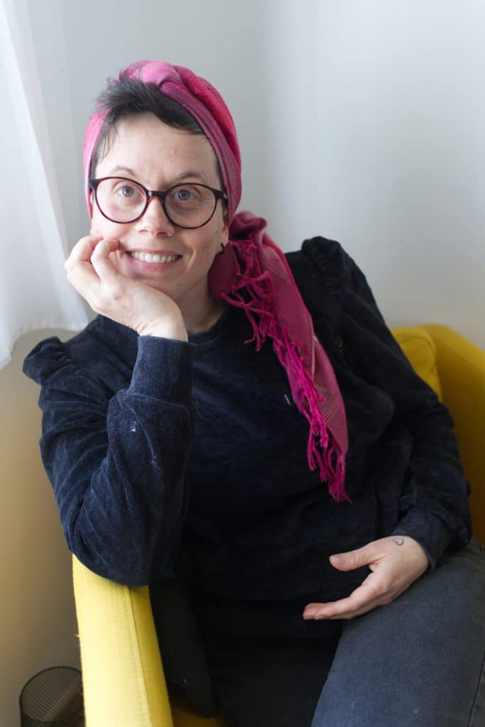 Femme souriante avec lunettes et foulard rose