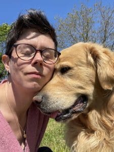 Femme aux lunettes câlinant un golden retriever